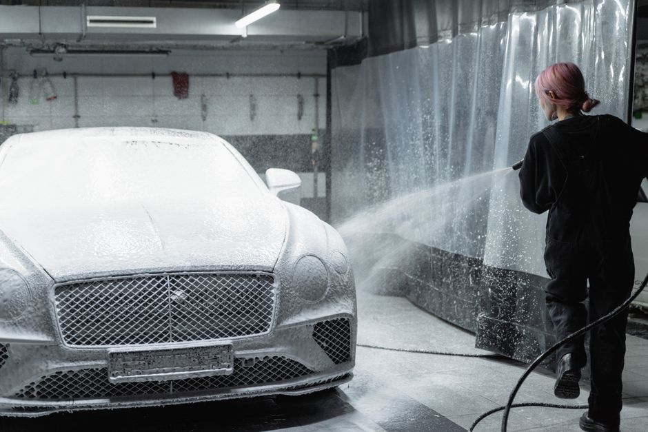 Professional pre-wash foam treatment preparing a vehicle's surface before paint correction work